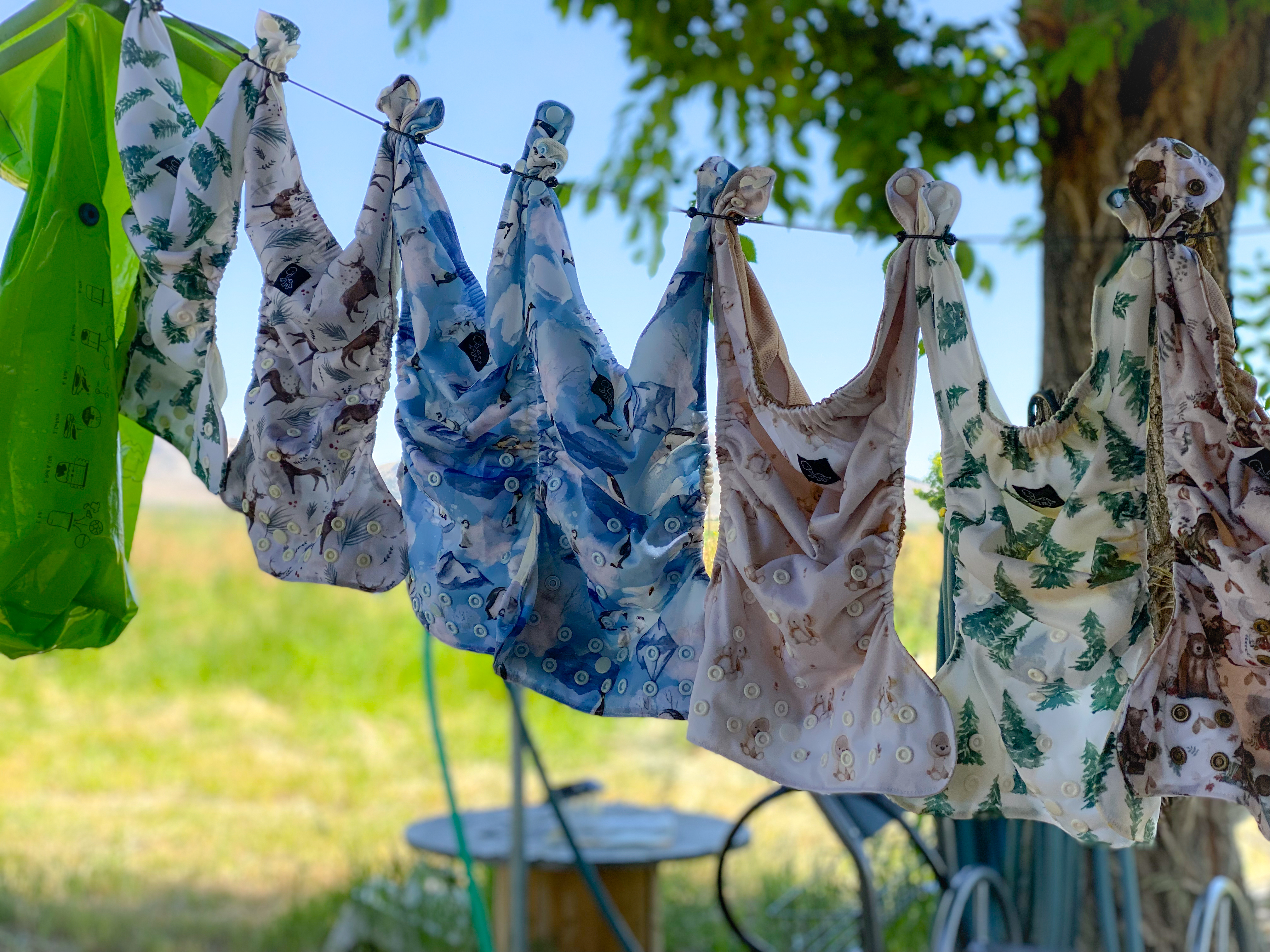 Cloth diaper inserts hanging from a clothesline on a sunny day.